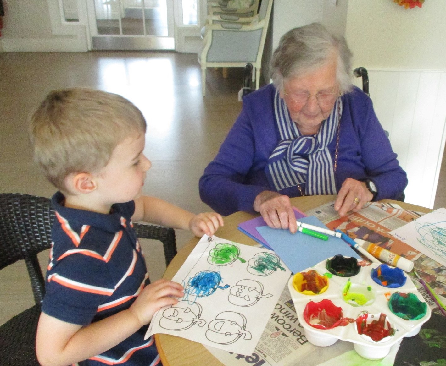 toddler and older person at MHA Belvedere Manor care home making cards and painting